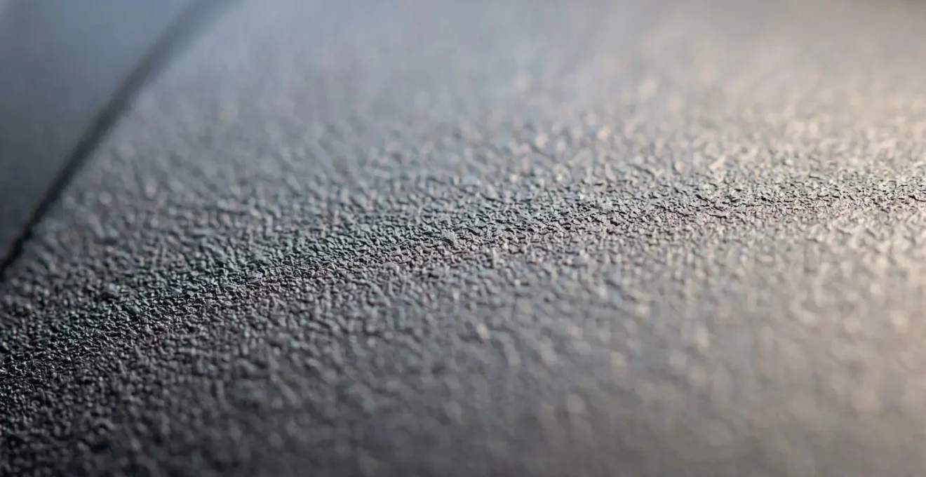 Gros plan macro d'une surface mate texturée illustrant l'effet de grain microscopique
